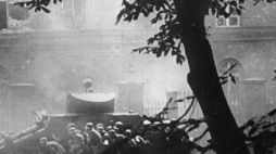 Niemiecka piechota pod osłoną samochodu pancernego zbliża się do budynku Poczty Polskiej. Źródło: PAP
