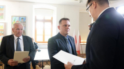 Przedstawiciele rodzin zamordowanych żołnierzy antykomunistycznego podziemia Jan Pecel (L) oraz Marcin Popiel (C) odbierają noty identyfikacyjne z rąk prezesa Fundacji Niezłomni Wojciecha Łuczaka (P). Fot. PAP/P. Polak