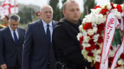 Gruziński prezydent Giorgi Margvelashvili (C) uczestniczy w uroczystości składania wieńców na cmentarzu w Tbilisi. Oficjalna ceremonia odbyła się tutaj z okazji dziesiątej rocznicy konfliktu rosyjsko-południowoosetyjsko-gruzińskiego. Fot. PAP/EPA