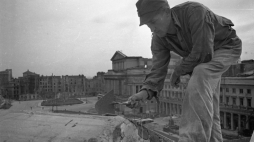 Warszawa, 1948-09. Robotnik na dachu kamienicy Johanna Christopha Hartmanna Petiscusa. W głębi plac Teatralny i Teatr Wielki. Fot. PAP/CAF