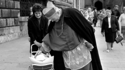 Karol Wojtyła pochylony nad wózkiem z dzieckiem, przy Katedrze Wawelskiej; fot. Adam Bujak; 1977 r. Źródło: Muzeum Narodowe w Krakowie