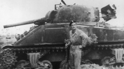 Bitwy pod Falaise: żołnierz 1 Dywizji Pancernej obok zniszczonego kanadyjskiego Shermana. Fot. NAC