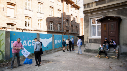 Artysta street artu Dariusz Paczkowski (L) wziął udział w malowaniu antywojennego, nawołującego do wzajemnego szacunku i dialogu muralu „PEACE” powstającego w Łodzi. Fot. PAP/G. Michałowski