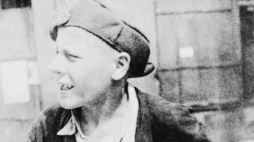 Mały powstaniec rozlepiający plakaty na ulicach Warszawy. PAP/Reprodukcja Jakub Grelowski.