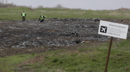 Śledczy przeczesują miejsce katastrofy pasażerskiego odrzutowca MH17 malezyjskich linii lotniczych obok tabliczki z napisem „Zakaz wstępu!” PAP/EPA/Alexander Ermochenko 