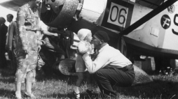 Porucznik pilot Franciszek Żwirko wita się ze swoim synkiem Heniem i żoną Agnieszką po przylocie na warszawskie lotnisko w sierpniu 1932 r.. Z tyłu widoczny samolot RWD-6. Fot. Narodowe Archiwum Cyfrowe.