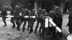 Łamanie szlabanu granicznego (niemieckie propagandowe zdjęcie pozowane, wykonane 1 września 1939 r.). Fot. Wikipedia.