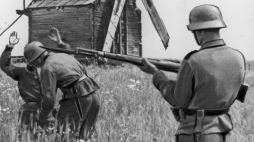 Niemieccy żołnierze rewidują cywila w poszukiwaniu broni, 1942 r. /Źródło: NAC