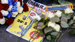 Specjalne wydanie „Charlie Hebdo” leży wśród wieńców i ołówków pozostawionych przed redakcją gazety podczas uroczystości upamiętniających 10. rocznicę ataku islamistów.  PAP/EPA/Ludovic Marin