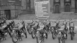 Maj 1955 r. Motocykle przeznaczone dla przodowników i racjonalizatorów hutnictwa wystawione przed Urzędem Wojewódzkim w Katowicach. Z tyłu obwieszczenie co jeszcze dostaną. Fot. PAP/CAF/Kazimierz Seko