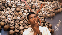 Phnom Penh, Kambodża: Robotnik z Kambodży modli się przed "mapą czaszek" (z tyłu), wykonanej z czaszek i kości na pamiątkę horroru pól śmierci, z muzeum Tuol Sleng, byłego centrum tortur, 10 marca 2002 r. w Phnom Penh. PAP/ EPA PHOTO AFPI