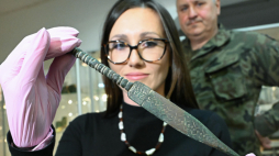 Katarzyna Herdzik ze Stowarzyszenia Eksploracyjnego Na Rzecz Ratowania Zabytków im. Św. Korduli w Kamieniu Pomorskim ogląda znaleziony w bryle gliny oderwanej od klifu na wybrzeżu Bałtyku sztylet z wczesnej epoki żelaza prezentowany w Muzeum Historii Ziemi Kamieńskiej, Fot. PAP/Marcin Bielecki