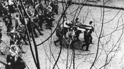 Gdynia 17.12.1970. Wydarzenia grudniowe 1970. Ulicą Świętojańską w kierunku centrum przechodzi pochód, demonstranci niosą na drzwiach zwłoki Zbigniewa Godlewskiego. Zbigniew Godlewski zginął w okolicy przystanku Szybkiej Kolei Miejskiej Gdynia Stocznia, przeszyty serią z karabinu maszynowego. Fot. PAP/Edmund Pepliński