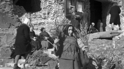 Kobieta sprzedająca palmy wielkanocne przed zrujnowanym kosciołem Świętego Krzyża w Warszawie (1945). Fot. PAP/CAF