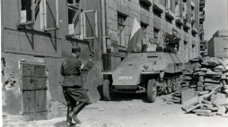 Wprowadzenie zdobytego transportera na teren powstańczy przez barykadę przy ul. Kopernika. Źródło: Wikipedia