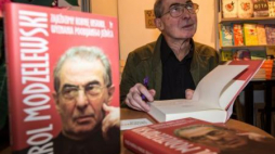 Karol Modzelewski ze swoją książką „Zajeździmy kobyłę historii wyznania poobijanego jeźdźca”. Fot. PAP/M. Kulczyński