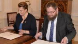 Minister Małgorzata Omilanowska i dyrektor Piotr M.A. Cywiński podczas podpisywania umowy. Źródło: Muzeum Auschwitz