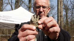 Prof. Krzysztof Szwagrzyk prezentuje orzełka z wojskowej czapki - poszukiwania szczątków żołnierzy Narodowych Sił Zbrojnych z oddziału "Bartka" w lesie koło Starego Grodkowa. 19.03.2016. Fot. PAP/K. Świderski