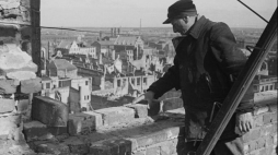 Odbudowa Bazyliki Mariackiej Wniebowzięcia Najświętszej Marii Panny - prace nad rekonstrukcją dachu świątyni; w tle ruiny Głównego Miasta i wyspa Ołowianka. Gdańsk, 1948 r. Fot. PAP/CAF