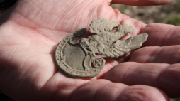 Orzełek z wojskowej czapki znaleziony w lesie koło Starego Grodkowa podczas poszukiwań szczątków żołnierzy z oddziału "Bartka" (Henryka Flamego) zamordowanych przez UB pod koniec lata 1946 r. Fot. PAP/K. Świderski