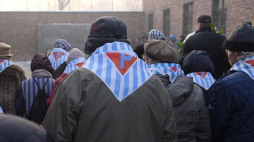Byli więźniowie składają kwiaty i zapalają znicze przed Ścianą Śmierci, przy bloku 11 byłego niemieckiego obozu Auschwitz I, w trakcie obchodów 72. rocznicy wyzwolenia KL Auschwitz-Birkenau. Fot. PAP/A. Grygiel