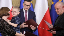 Premier Mateusz Morawiecki (C) wręcza akty nadania obywatelstwa polskiego repatriantom podczas spotkania w Domu Polonii w Pułtusku. Fot. PAP/P. Supernak