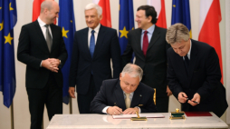Warszawa 2009-10-10. Prezydent Lech Kaczyński (C) podpisał 10 bm. akt ratyfikacji Traktatu Lizbońskiego, w Warszawie. Prezydencki podpis kończy procedurę ratyfikacji Traktatu w Polsce. W tle stoją od lewej: premier Szwecji Frederik Reinfeldt, przewodniczący Parlamentu Europejskiego Jerzy Buzek i szef Komisji Europejskiej Jose Manuel Barroso. Fot. PAP/J. Turczyk