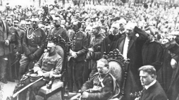 Uroczystość z udziałem szefa misji pomocy dla ofiar I wojny światowej Herberta Hoovera (siedzi pierwszy z prawej), Naczelnika Państwa Józefa Piłsudskiego (siedzi pierwszy z lewej), nuncjusza papieskiego Achillesa Rattiego (siedzi w środku), premiera Ignacego Jana Paderewskiego (stoi za nuncjuszem papieskim). Warszawa, 08.1919. Fot. NAC
