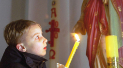 Mińsk, Białoruś, 26.12.2000. Chłopiec trzyma świecę w czasie mszy wigilijnej dla dzieci w kościele rzymsko-katolickim w Mińsku w niedzielę, 24 bm. Fot. PAP/EPA/W. Draczew