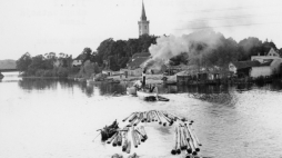 Mikołajki, lata 50. Spław drewna przez jezioro Mikołajskie; w oddali widoczne Mikołajki i kościół św. Trójcy. PAP/CAF