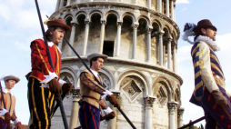 Piza, Wlochy, 16.12.2001. Gwardia honorowa w historycznych strojach mija krzywą wieżę w Pizie po tym, jak zabytek został ponownie udostępniony zwiedzającym po zakończeniu po 12 latach prac renowacyjnych pod kierunkiem prof. Michała Jamiołkowskiego. PAP/EPA