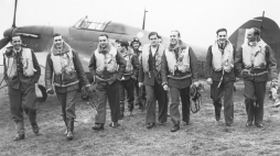 1940 r. Piloci Dywizjonu 303. Od lewej P/O Ferić, F/Lt Kent, F/O Grzeszczak, P/O Radomski, P/O Zumbach, P/O Łukuciewski, F/O Henneberg, Sgt. Rogowski, Sgt. Szaposznikow. Źródło: Wikipedia Commons