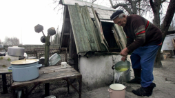 Ilintsy, Ukraina, 23.04.06. Michaił Ratkiewicz, mieszkaniec wsi Ilintsy, około 20 km od elektrowni czarnobylskiej, nabiera wodę przed swym domem. Ponad 330 mieszkańców zagrożonych promieniowaniem odmówiło zmiany miejsca zamieszkania w 1986 roku po eksplozji reaktora nr 4 i wybrało życie 30 km od miejsca wybuchu. Fot. PAP/EPA