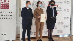 Wiceminister Wanda Zwinogrodzka wraz z Dyrektorem NCK R. Wiśniewskim wręczają dyplomy ministra MKDNiS stypendystom tegorocznej edycji programu „Gaude Polonia”. Źródło: www.twitter.com/MKDNiS