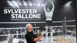 Prezentacja pamiątek Sylvestra Stallone'a wystawionych na aukcję, w tle fotografia aktora jako Rocky Balboa. Fot. PAP/EPA