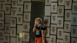 Chłopiec zwiedzający memoriał upamiętniający ponad 500 poległych i zidentyfikowanych ofiar rosyjskiej zbrodni w Buczy. Sierpień 2022 r. EPA/O. Petrasyuk