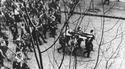 Ulicą Świętojańską w kierunku centrum przechodzi pochód, demonstranci niosą na drzwiach zwłoki Zbigniewa Godlewskiego. Zbigniew Godlewski zginął w okolicy przystanku Szybkiej Kolei Miejskiej Gdynia Stocznia, przeszyty serią z karabinu maszynowego. Gdynia 17.12.1970.  PAP/Edmund Pepliński