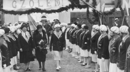 Michalina Mościcka (trzyma bukiet kwiatów) w towarzystwie dwóch kobiet przechodzi przed szpalerem wioślarek, lata 1927-1930. /NAC