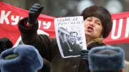Kobieta wybija się ponad tłum, biorąc udział w wiecu pod hasłem „Ukraina bez Kuczmy” przed budynkiem parlamentu w Kijowie, w czwartek 21 grudnia 2000 roku. Trzyma zdjęcie zaginionego dziennikarza śledczego Georgija Gongadze. Fot. EPA – SERGEJ SUPINSKI