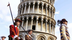 Gwardia honorowa w historycznych strojach mija krzywą wieżę w Pizie. fot PAP/EPA/FRANCO SILVI