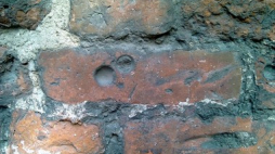 Dołki pokutne na murze kościoła. Fot. domena publicza