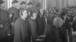 Warszawa, 1947-03-03. Odczytanie wyroku w procesie niemieckich zbrodniarzy wojennych (w drugim rzędzie): byłego szefa tzw. dystryktu warszawskiego Ludwika Fischera (1L), byłego starosty miejskiego w Warszawie Ludwika Leista (2L), byłego komendanta policji bezpieczeństwa Josefa Meisingera (3L) i płk. policji, byłego szefa wydziału w komendzie policji porządkowej Maksa Daume (4L). Proces przed Najwyższym Trybunałem Narodowym toczył się w dniach 17.12.1946 - 24 .02.1947. Nz. oskarżeni wysłuchują sentencji wyro