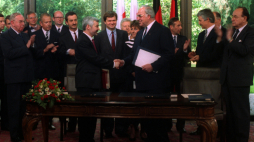 Niemcy, Bonn, 1991-06-17. Podpisanie traktatu między Rzecząpospolitą Polską a Republiką Federalną Niemiec o dobrym sąsiedztwie i przyjaznej współpracy. Nz. premier RP Jan Krzysztof Bielecki (L) i Kanclerz Niemiec Helmut Kohl wymieniają uścisk dłoni po podpisaniu dokumentu. Wśród polityków m.in. Bogusław Marczewski (1L), Piotr Ogonowski (2L częściowo zasłonięty), minister spraw zagranicznych Polski Krzysztof Skubiszewski (3L), szef polskiego protokołu dyplomatycznego Janusz Świtkowski (5L), polski dyplomata 