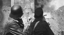 Powstańcy z batalionu „Kiliński” na barykadzie na ul. Zielnej obserwują płonący gmach PAST-y. Fot. PAP/Alamy