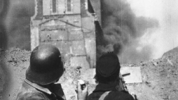 Powstańcy z batalionu „Kiliński” na barykadzie na ul. Zielnej obserwują płonący gmach PAST-y. Fot. PAP/Alamy