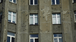 Dziury po pociskach w ścianie kamienicy przy ul. Chmielnej 73B róg Żelaznej (2014 r.). Fot Arch. PAP