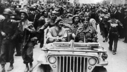 Wkroczenie 2. Korpusu Polskiego do Bolonii: generałowie Zygmunt Szyszko-Bohusz (1. z lewej) i Klemens Rudnicki (za kierownicą) w samochodzie Willys MB; z lewej strony widoczne samochody pancerne T17 (Staghound). 21.04.1945. Fot. NAC