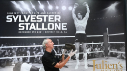 Prezentacja pamiątek Sylvestra Stallone'a wystawionych na aukcję, w tle fotografia aktora jako Rocky Balboa. Fot. PAP/EPA