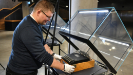 Gdańsk, 25.01.2023. Kierownik działu zbiorów Wojciech Łukaszun prezentuje polską replikę maszyny szyfrującej "Enigma" ze zbiorów Muzeum Historii Polski w Warszawie w ramach cyklu "Wejście w historię" w Muzeum II Wojny Światowej w Gdańsku, 25 bm. W dniu 25 stycznia obchodzony jest Dzień Kryptologii. Fot. PAP/A. Warżawa
