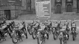 Maj 1955 r. Motocykle przeznaczone dla przodowników i racjonalizatorów hutnictwa wystawione przed Urzędem Wojewódzkim w Katowicach. Z tyłu obwieszczenie co jeszcze dostaną. Fot. PAP/CAF/Kazimierz Seko